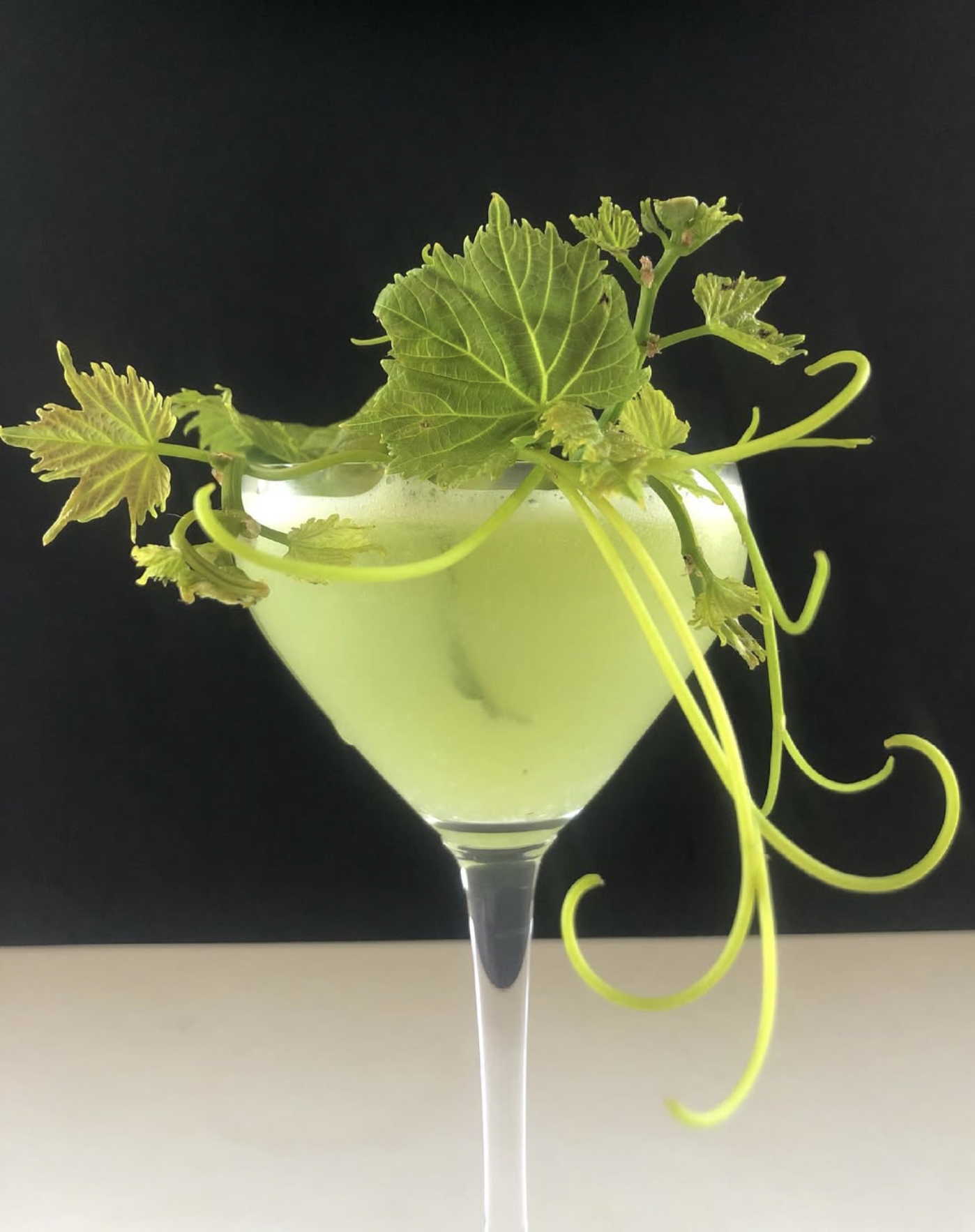 Green cocktail with grape leaves and tendrils